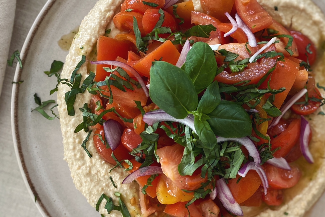 Tomaten-Salat mit Basilikum auf Kichererbsen-Hummus